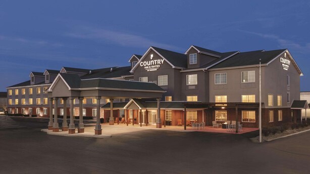 A Country Inn & Suites building with multiple units, a covered outdoor seating area, and a well-lit entrance. - Country Inn & Suites by Radisson, London, KY (London)