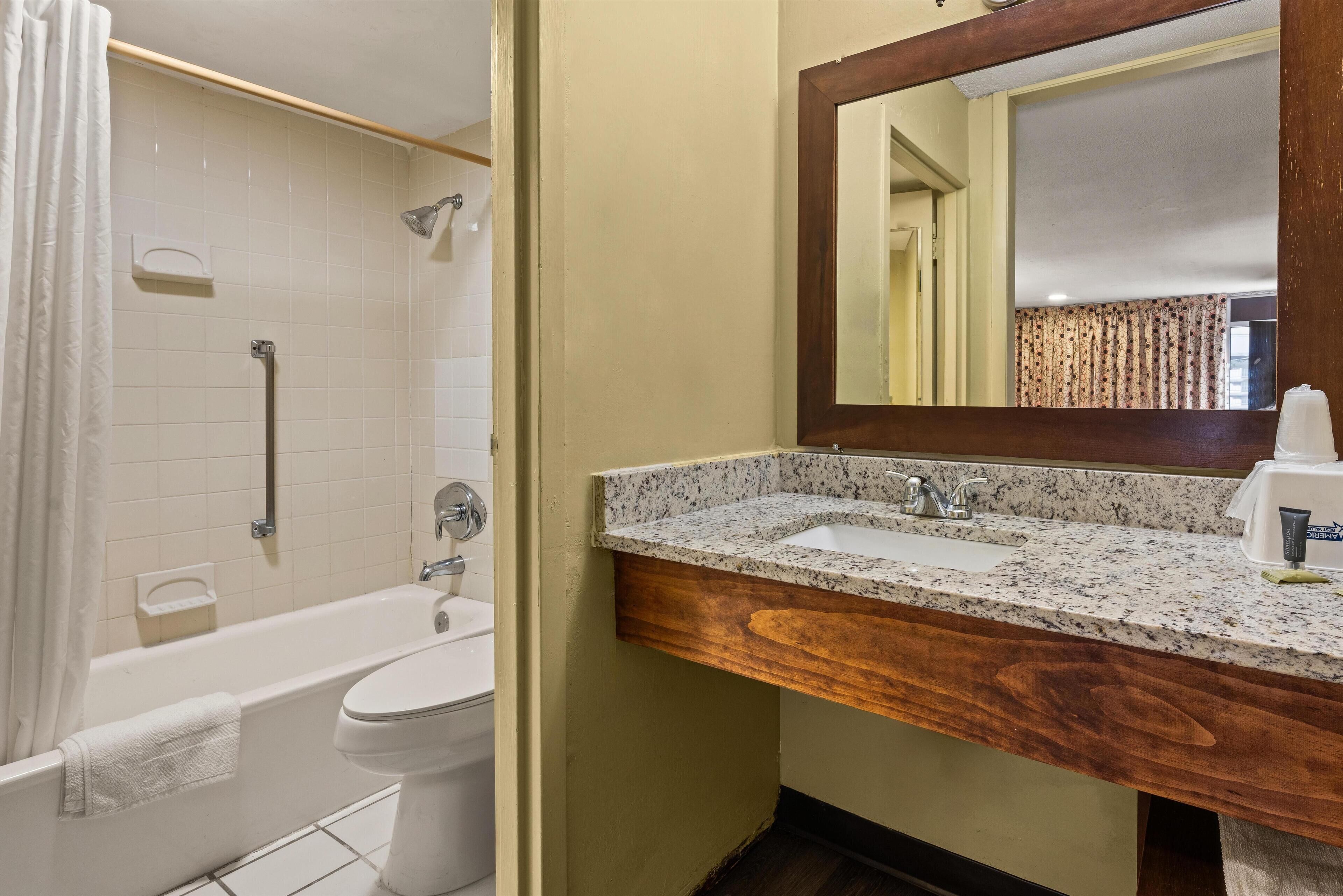 Un baño con bañera, inodoro y lavamanos.