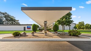 A gas station with a canopy, a sign indicating '1815 A', and landscaped areas with bushes and rocks. - Americas Best Value Inn Wilson (Wilson)