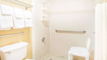 Un baño pequeño para una sola persona, con inodoro, ducha y barra de apoyo.