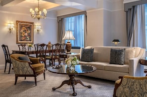 A well-appointed living room with a sofa, armchairs, a dining table, and a chandelier. - Warwick New York (New York)