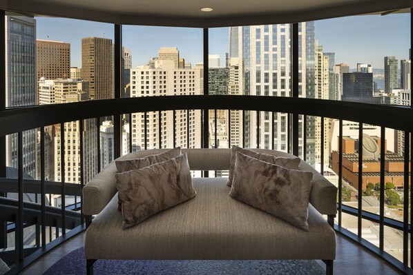 A high-rise room with a curved balcony, a sofa with patterned cushions, and a city view. - San Francisco Marriott Marquis (San Francisco)