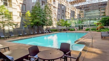 Una piscina al aire libre de temporada, sillones reclinables de piscina
