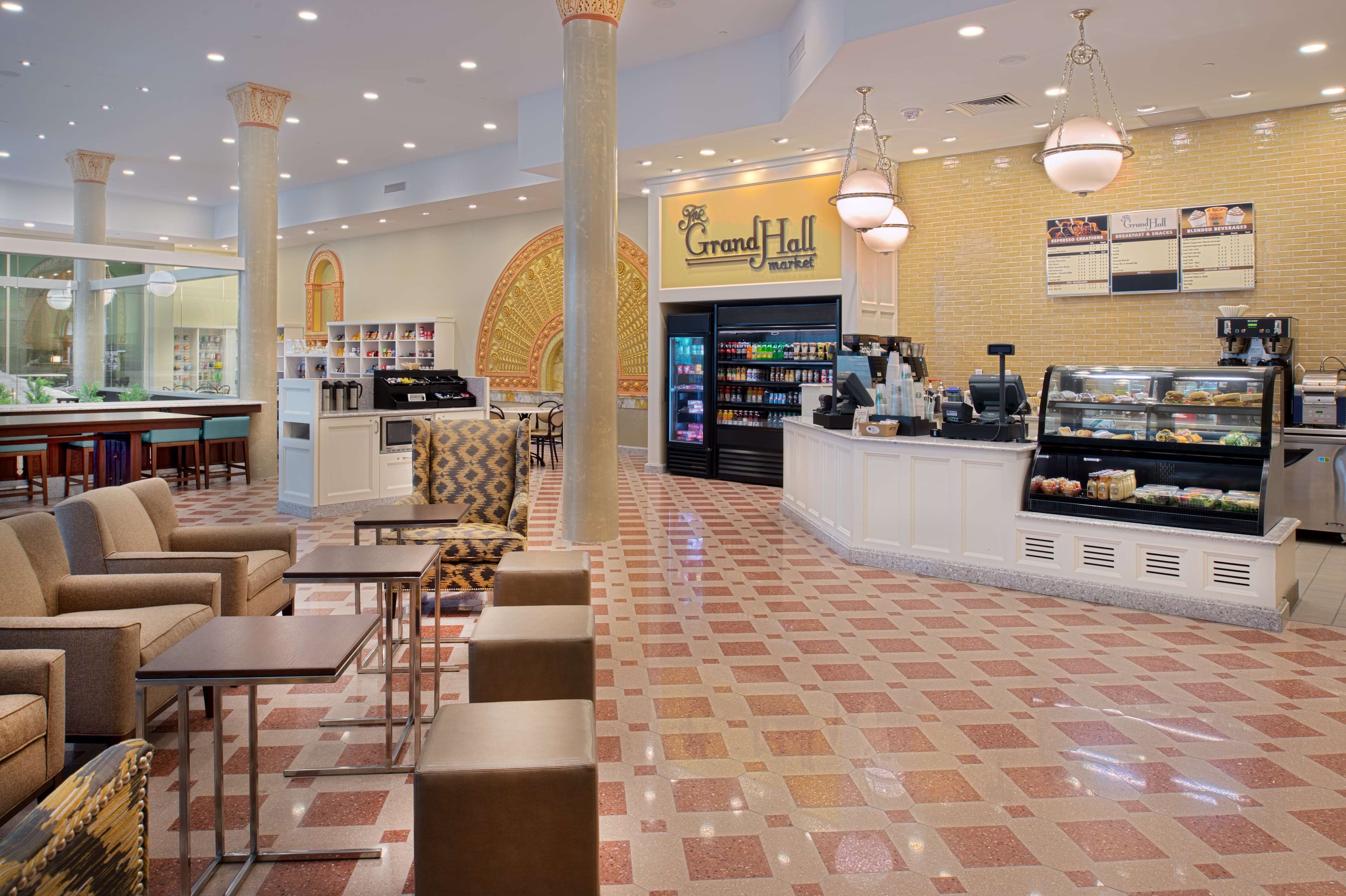 A Grand Hall Market with a food display, seating area, and a coffee station.