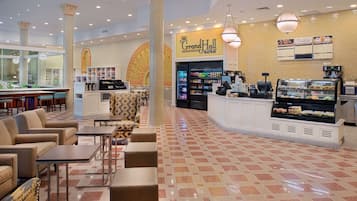 A Grand Hall Market with a food display, seating area, and a coffee station.