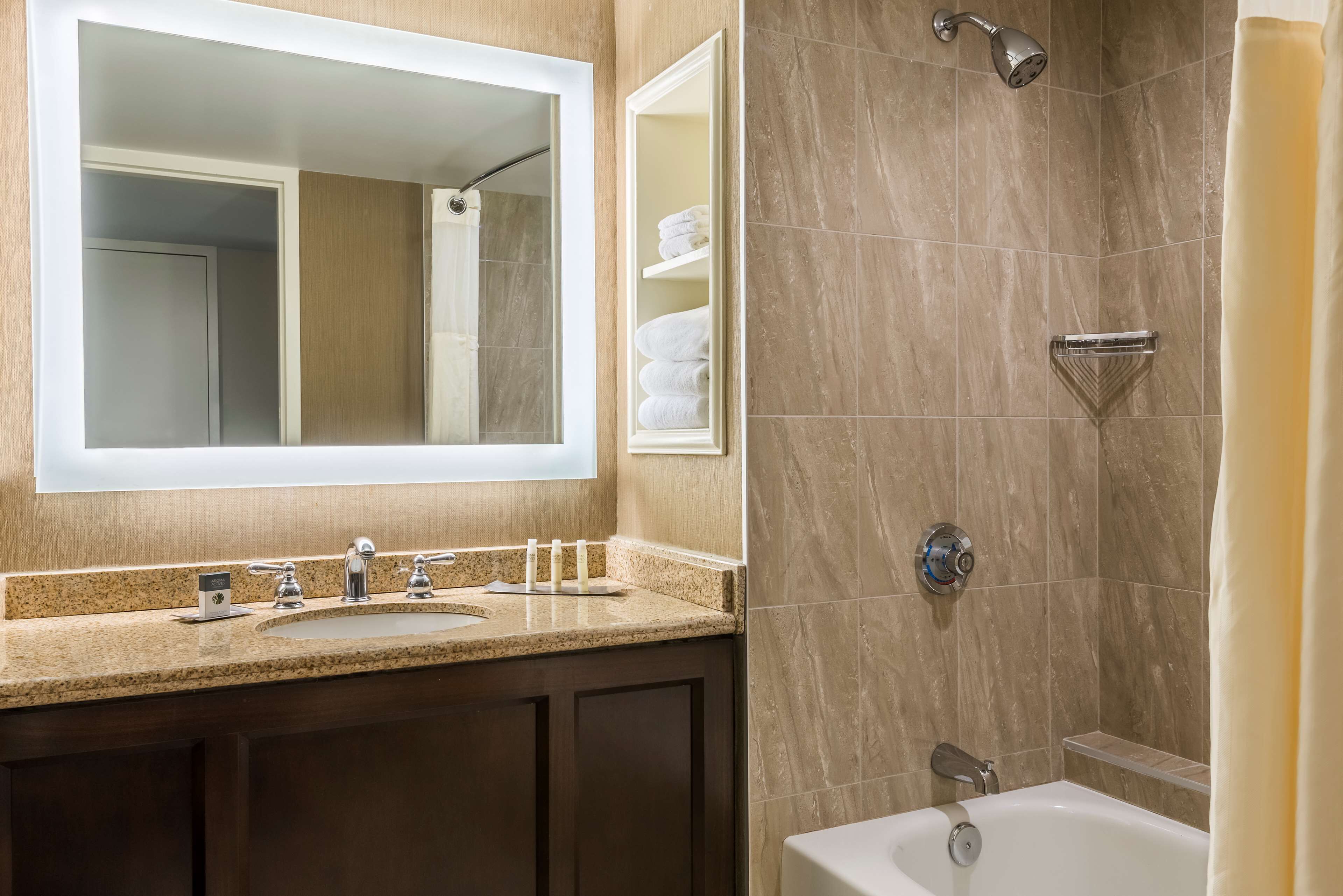 Un baño con lavamanos, espejo y ducha.