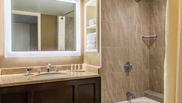 Un baño con lavamanos, espejo y ducha.