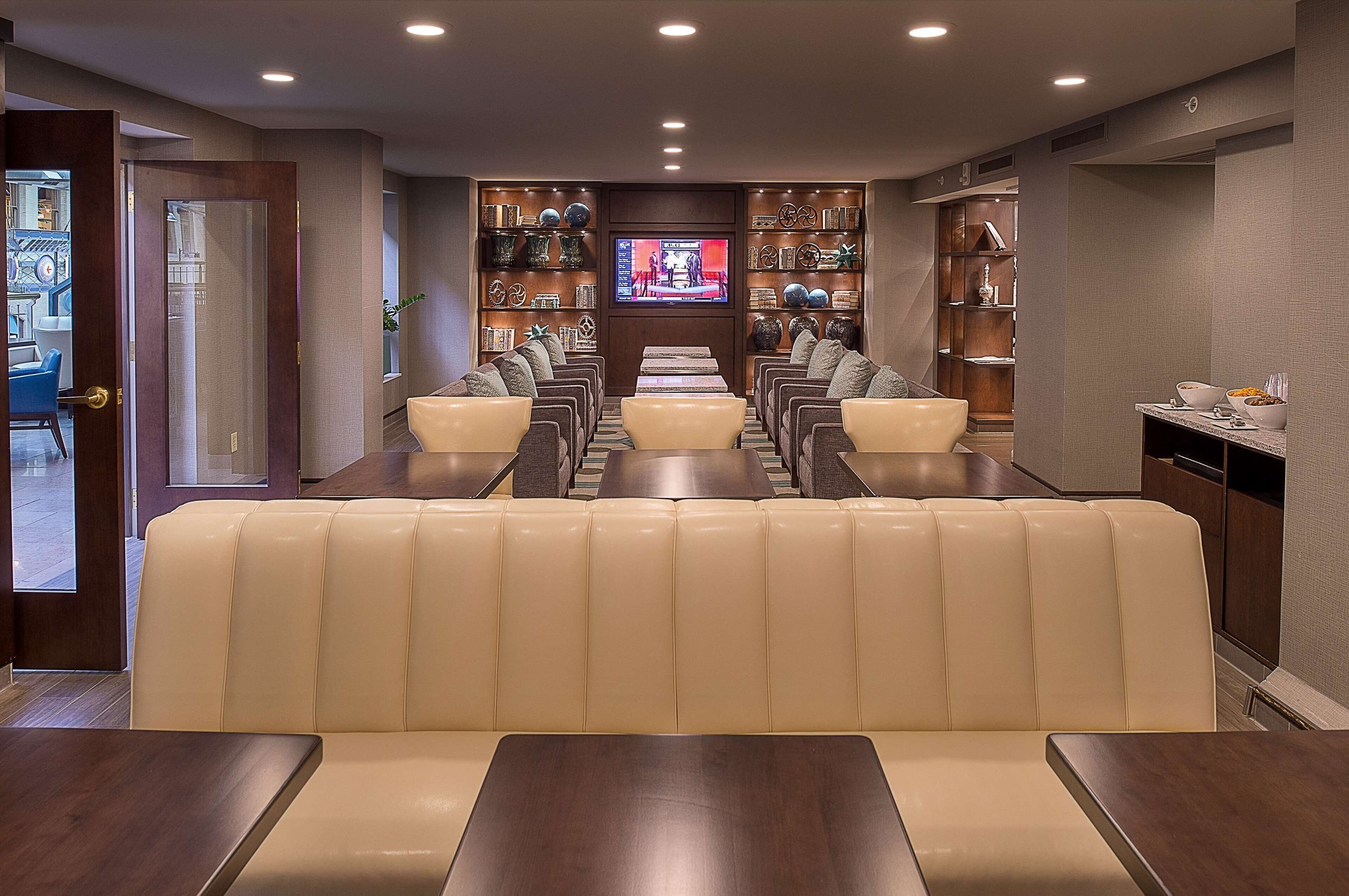 A restaurant with a long counter and cushioned seating.