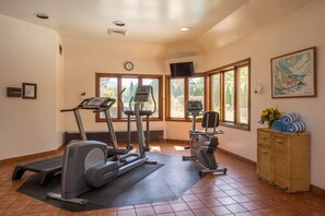 A gym with exercise equipment, large windows, and a clock on the wall. - The Orchards Hotel (Williamstown)
