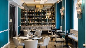 A modern restaurant with a bar area, seating arrangements, and a wine display. - Plaza Hotel Lucchesi (Florence)