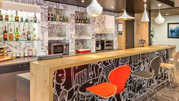 A bar area with a counter, shelves with bottles, a coffee machine, and a microwave.