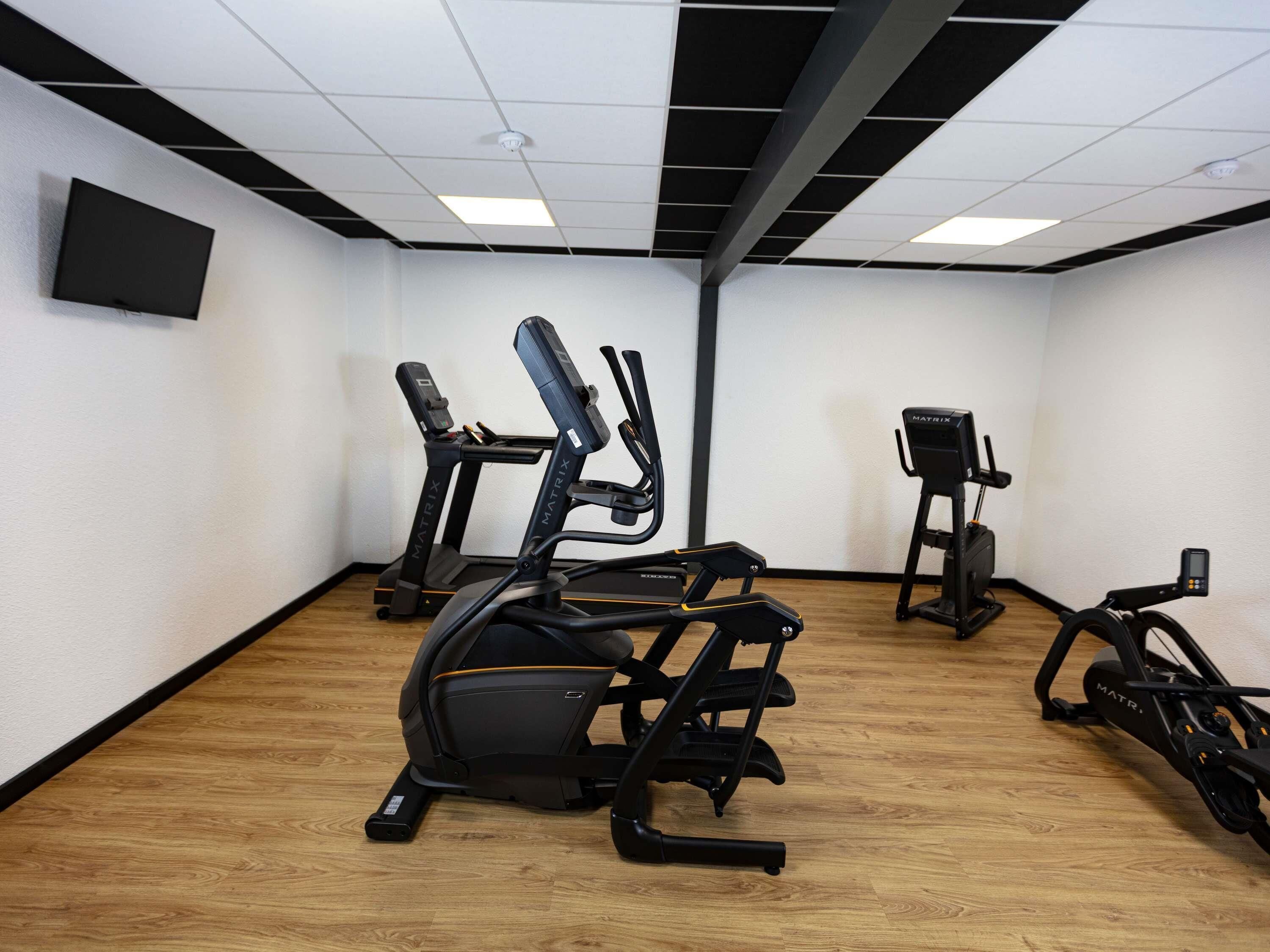 A gym with treadmills, an elliptical, and a stationary bike.