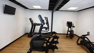 A gym with treadmills, an elliptical, and a stationary bike.