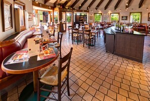 A restaurant with booths, tables, and a bar area.