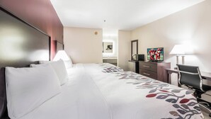 A hotel room with a large bed, a desk, a chair, a television, and a mirror. - Red Roof Inn Cadiz (Cadiz)