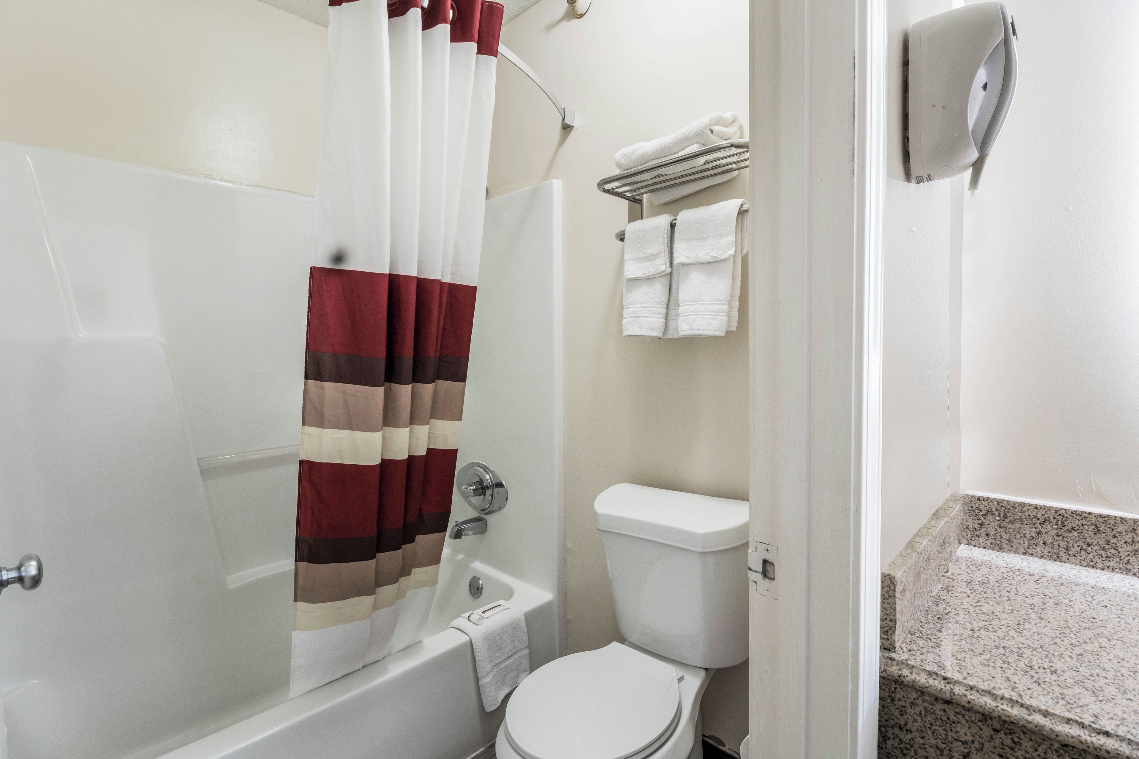 Ein Badezimmer mit Dusche, Toilette und Handtuchhalter.