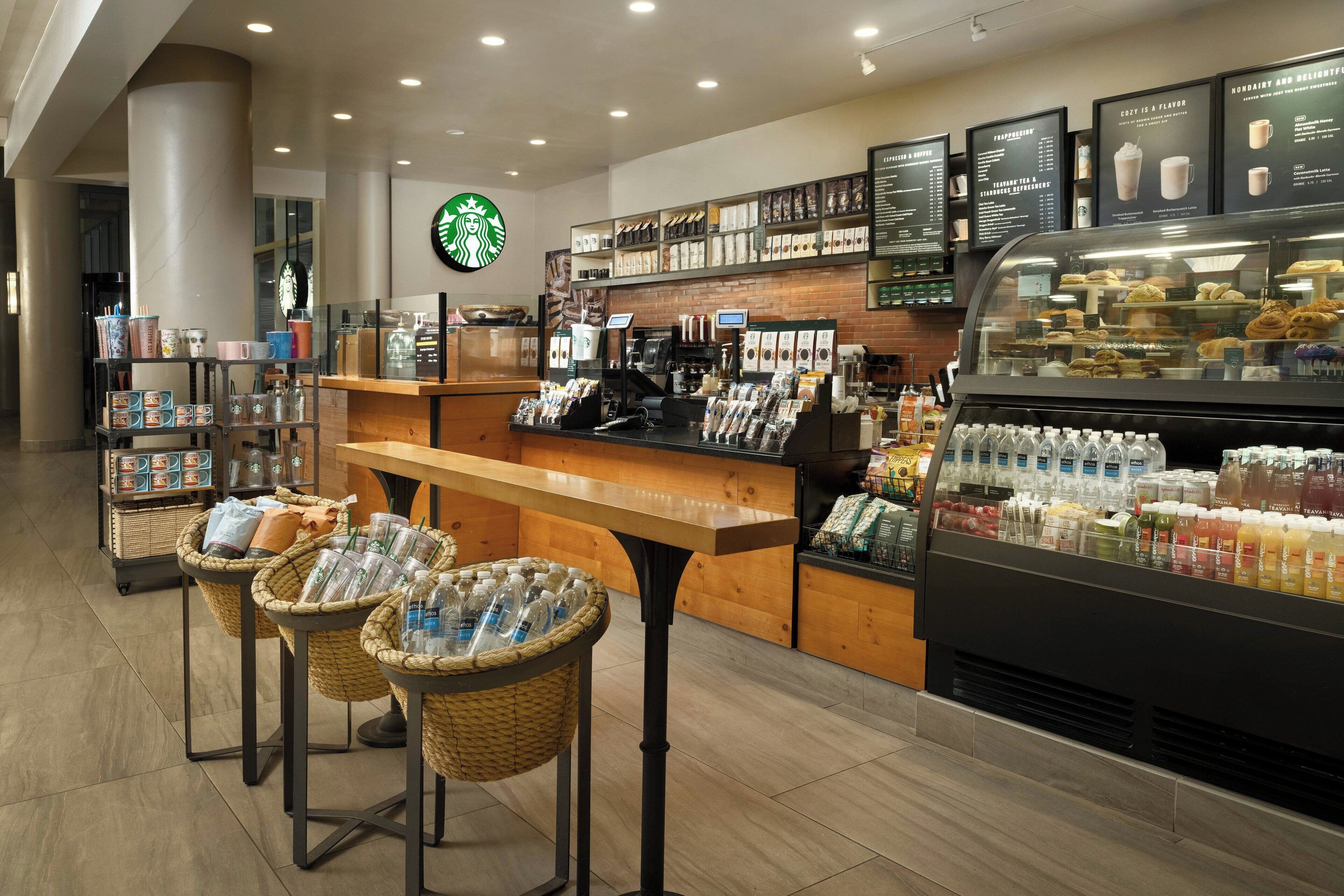 A Starbucks coffee shop interior with a counter, display cases, and a beverage display.