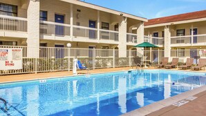 A hotel with a pool area, multiple balconies, and a sign indicating no diving. - Motel 6 Baytown, TX - Garth Rd (Baytown)