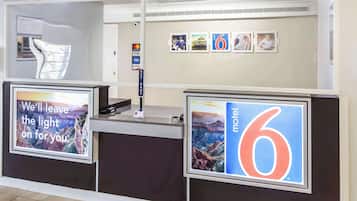 A reception desk with a '6' sign, a 'Key Drop' sign, and a 'Visa' sign.