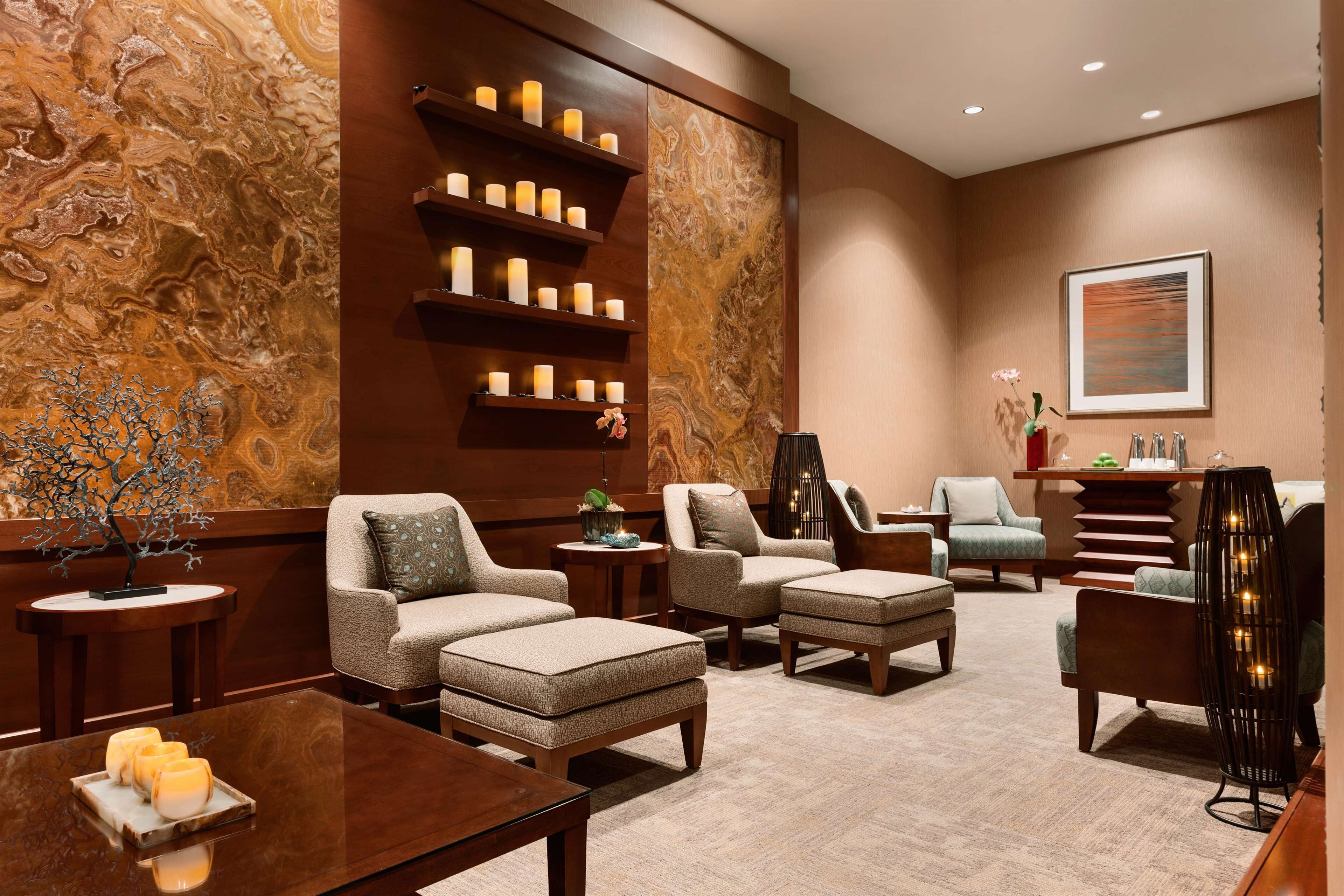 A modern lounge area with sofas, a coffee table, and a wall with a marble-like texture.