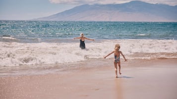 On the beach, white sand, beach cabanas, sun loungers