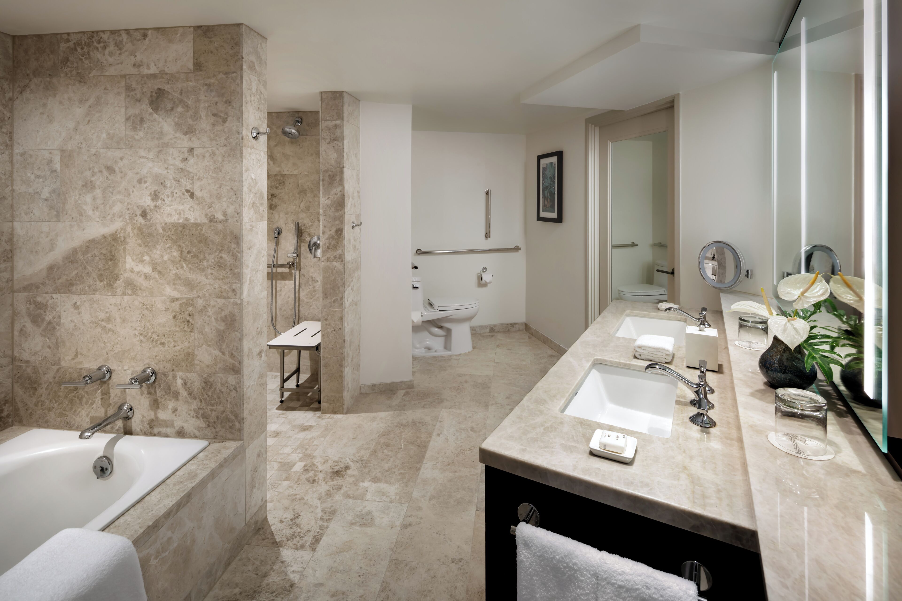 A modern bathroom with a bathtub, shower, and two sinks.