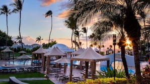 A resort pool area with lounge chairs, umbrellas, and palm trees. - Fairmont Kea Lani Maui (Kihei)