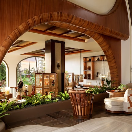 A spacious lobby with a curved wooden ceiling, a seating area with a patterned sofa, and a view of the outdoors through large windows.