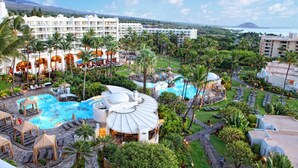 A resort with a large swimming pool, palm trees, and a view of the ocean. - Fairmont Kea Lani Maui (Kihei)