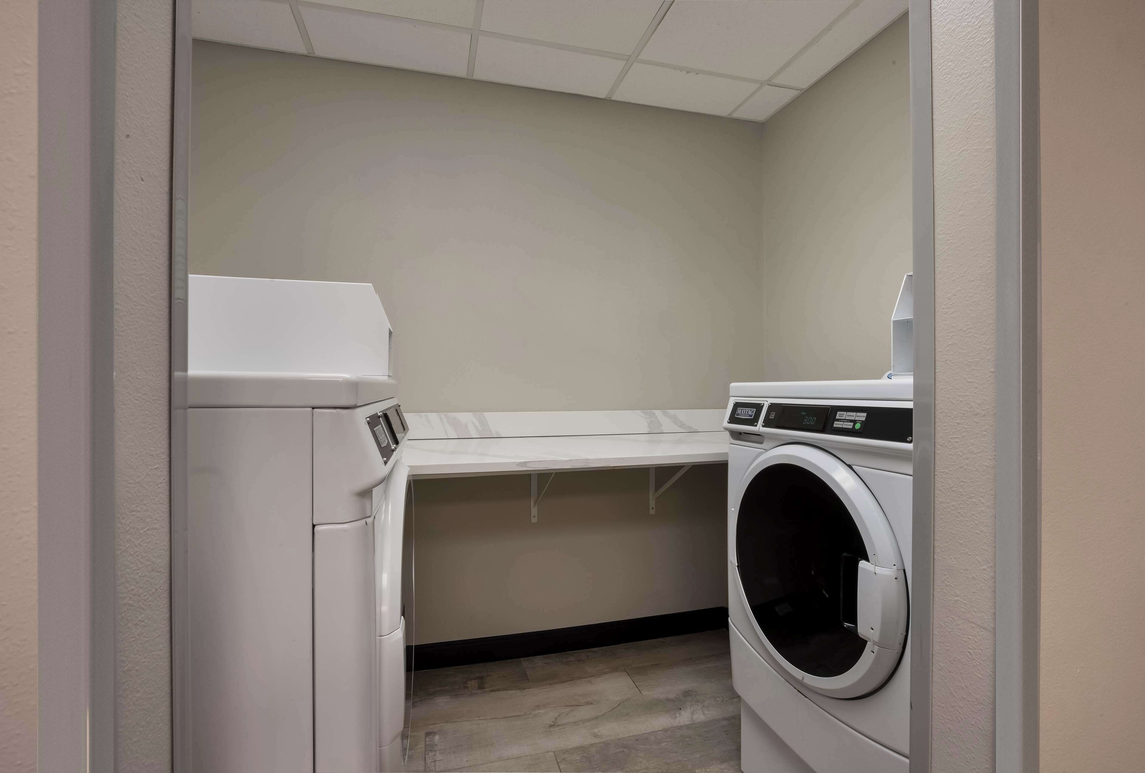 A laundry room with a washing machine, dryer, and a countertop.
