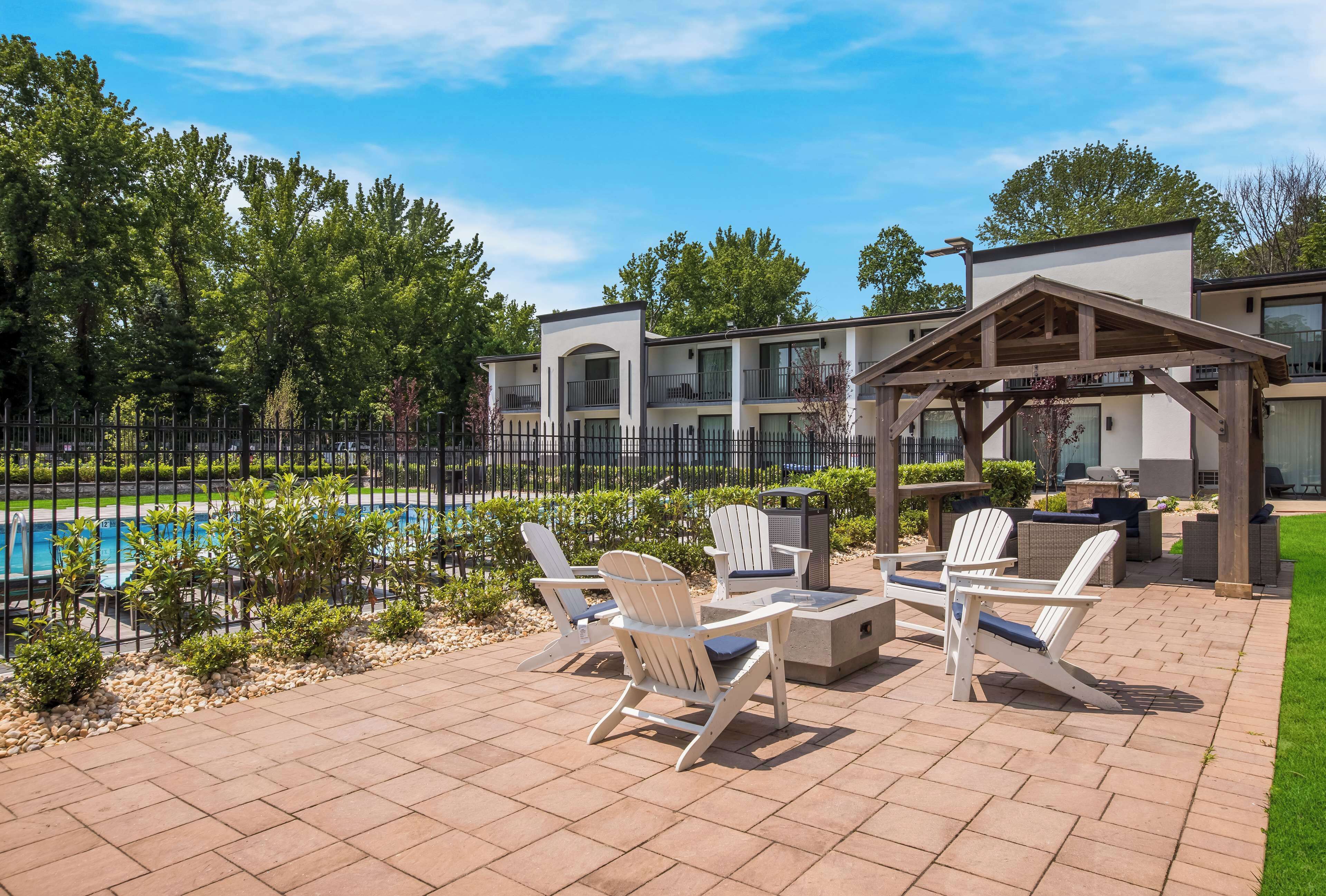 Un patio con mobiliario exterior y una piscina.