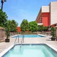 Una piscina al aire libre, sillones reclinables de piscina