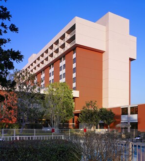 Un hôtel moderne doté d’un toit plat, de nombreux balcons et d’un espace piscine.