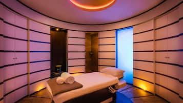 Relax in a spacious room with a large bed, a wooden bedside table, and a door with a glass panel.