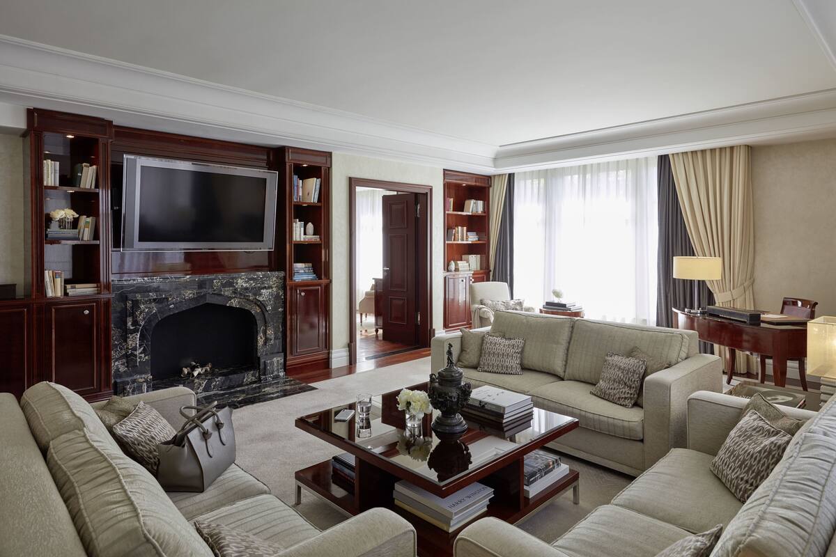 Un salón amplio con chimenea, asientos cómodos y un televisor de pantalla plana grande.