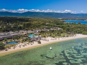 An aerial view of a resort with a swimming pool, beach, and clear waters. - Sofitel Mauritius L'Imperial Resort & Spa (Flic-en-Flac)