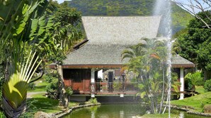 A building with a water fountain, surrounded by greenery and a mountain in the background. - Sofitel Mauritius L'Imperial Resort & Spa (Flic-en-Flac)