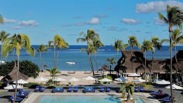 Una piscina al aire libre, sombrillas, sillones reclinables de piscina