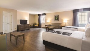 A hotel room with a large bed, a desk, a chair, a television, a dresser, and a window with curtains. - Wingate by Wyndham Galveston Beachfront at the Seawall (Galveston)