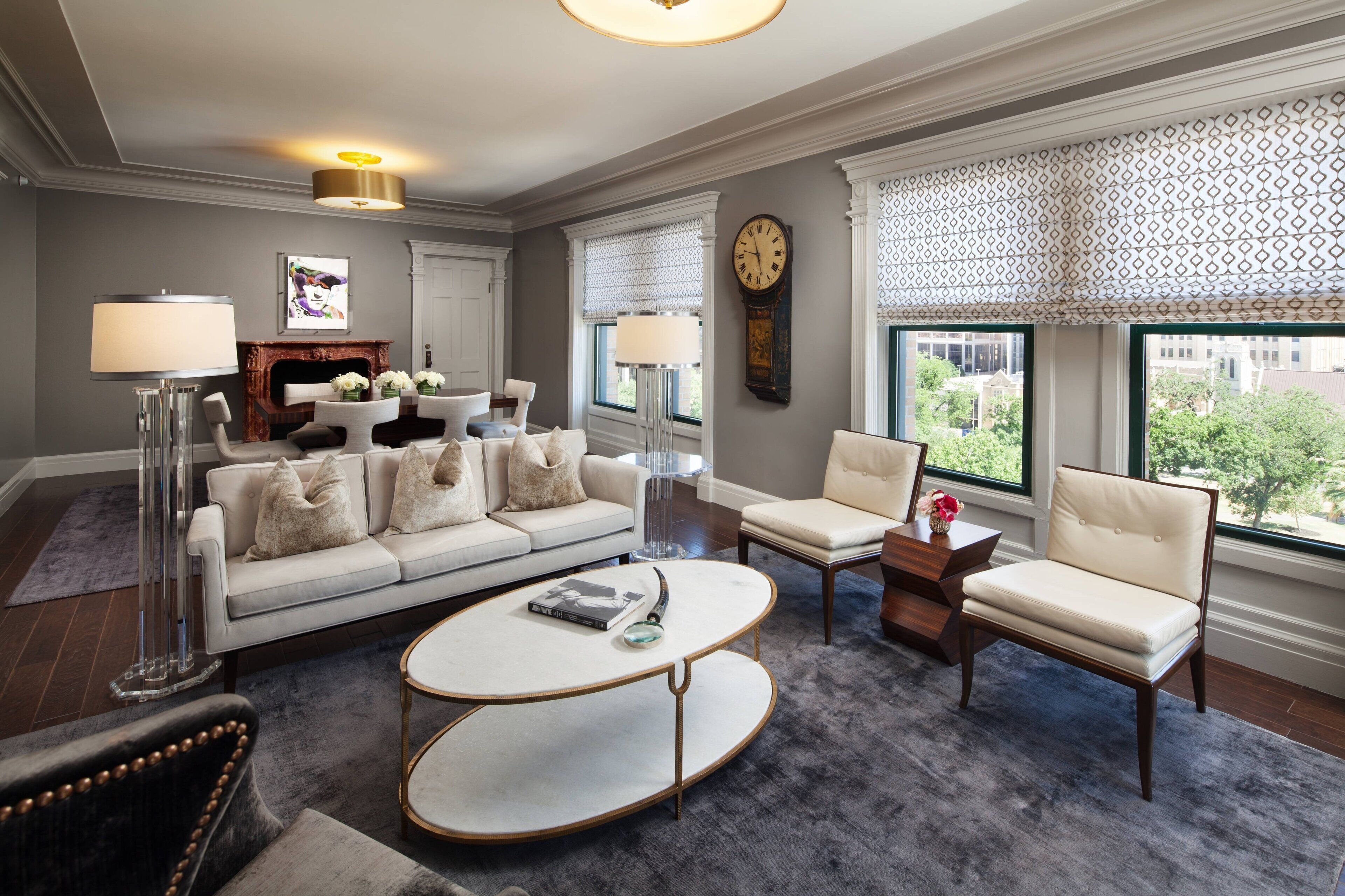 A modern living room with a sofa, armchairs, a coffee table, and a fireplace.
