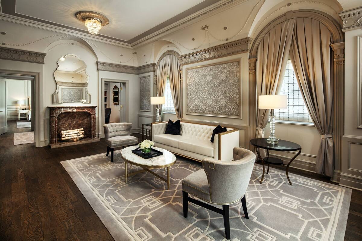 A luxurious living room with a fireplace, a sofa, armchairs, and a coffee table.