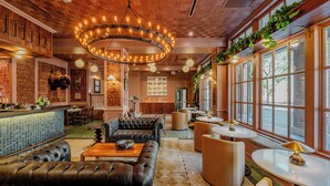 A modern lounge area with leather seating, a bar, and large windows. - The St. Anthony, A Luxury Collection Hotel, San Antonio (San Antonio)