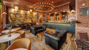 A bar area with leather sofas, round tables, and a mural on the wall. - The St. Anthony, A Luxury Collection Hotel, San Antonio (San Antonio)