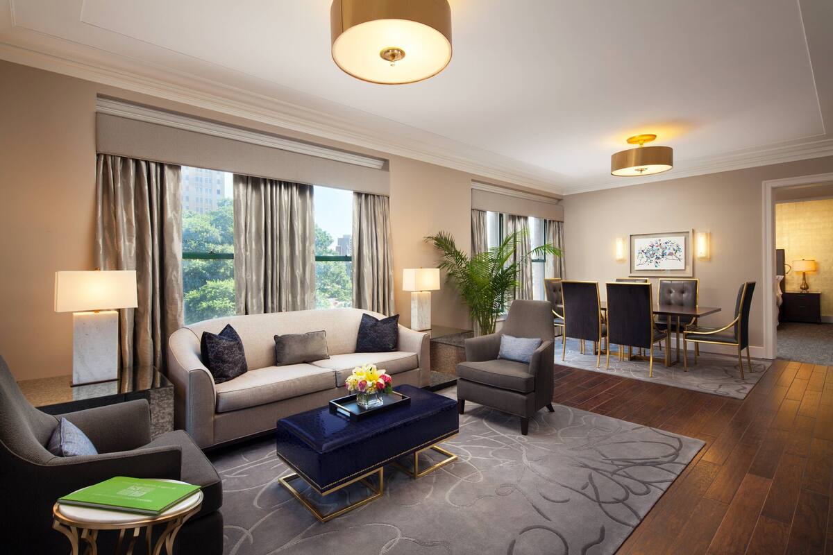 A spacious living area with a sofa, armchairs, a coffee table, and a dining set.