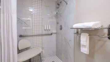 Un baño moderno con ducha, inodoro y barra para toallas.