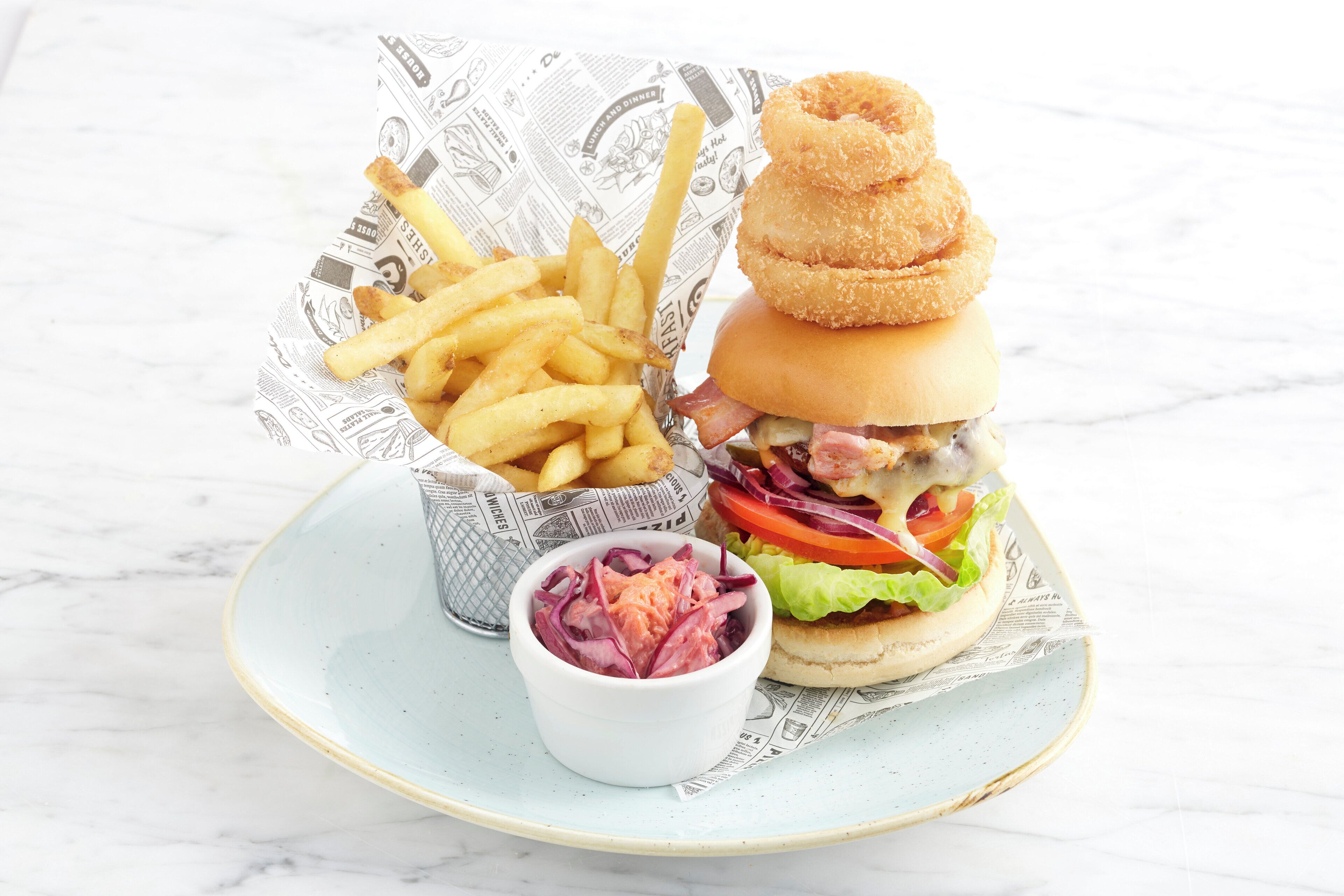 A plate with a burger, fries, and a small bowl of salad.