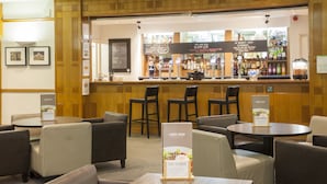 A bar area with a counter, bar stools, and a lounge menu sign.