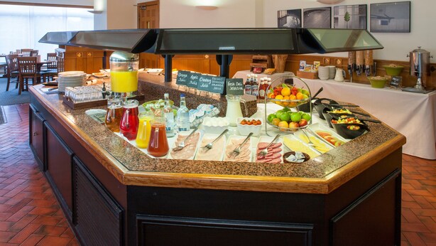 A buffet counter with various food items and beverages.