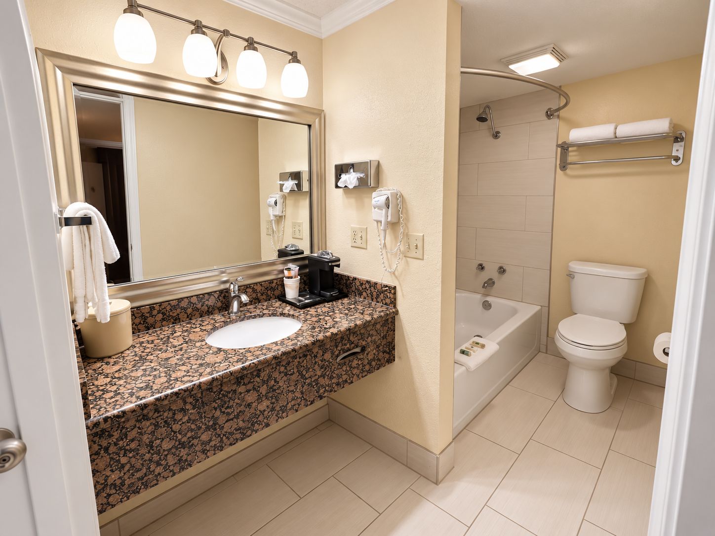 A bathroom with a sink, mirror, towel rack, and a shower area.