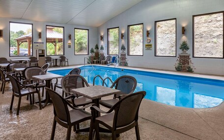 An indoor pool area with seating and a sign indicating a lifeguard on duty.